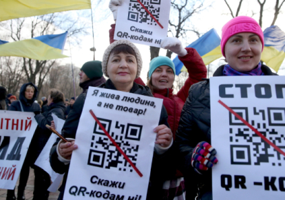 Антивакцинаторы с плакатами, на которых изображен QR-код партии "Единая Россия"