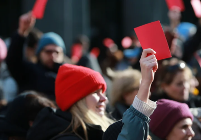 Митингующие держат "красные карточки" возле парламента Грузии, где продолжается инаугурация новоизбранного президента Михеила Кавелашвили, 29 декабря 2024 года